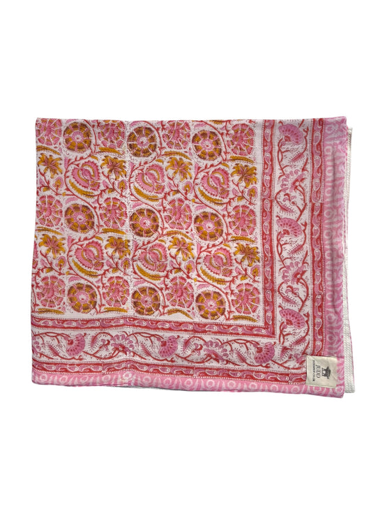A folded square scarf or shawl featuring a detailed pink, orange, and white block print pattern with floral and paisley motifs, shown against a plain white background.
