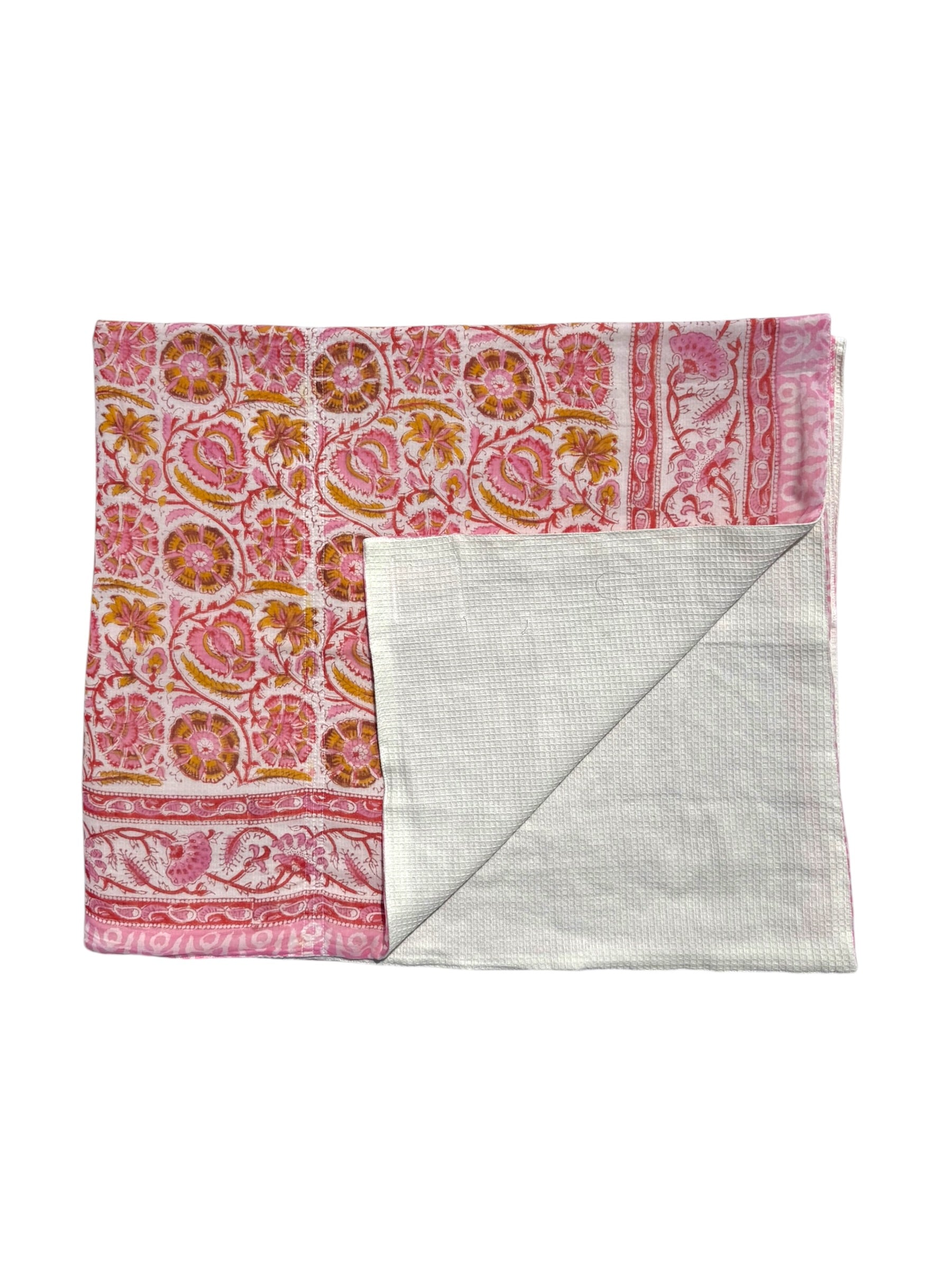 A folded cotton handkerchief with a pink, orange, and yellow floral block print on one side and a textured light gray reverse side, shown on a plain white background.