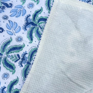Textured light green fabric on a patterned blue and white background