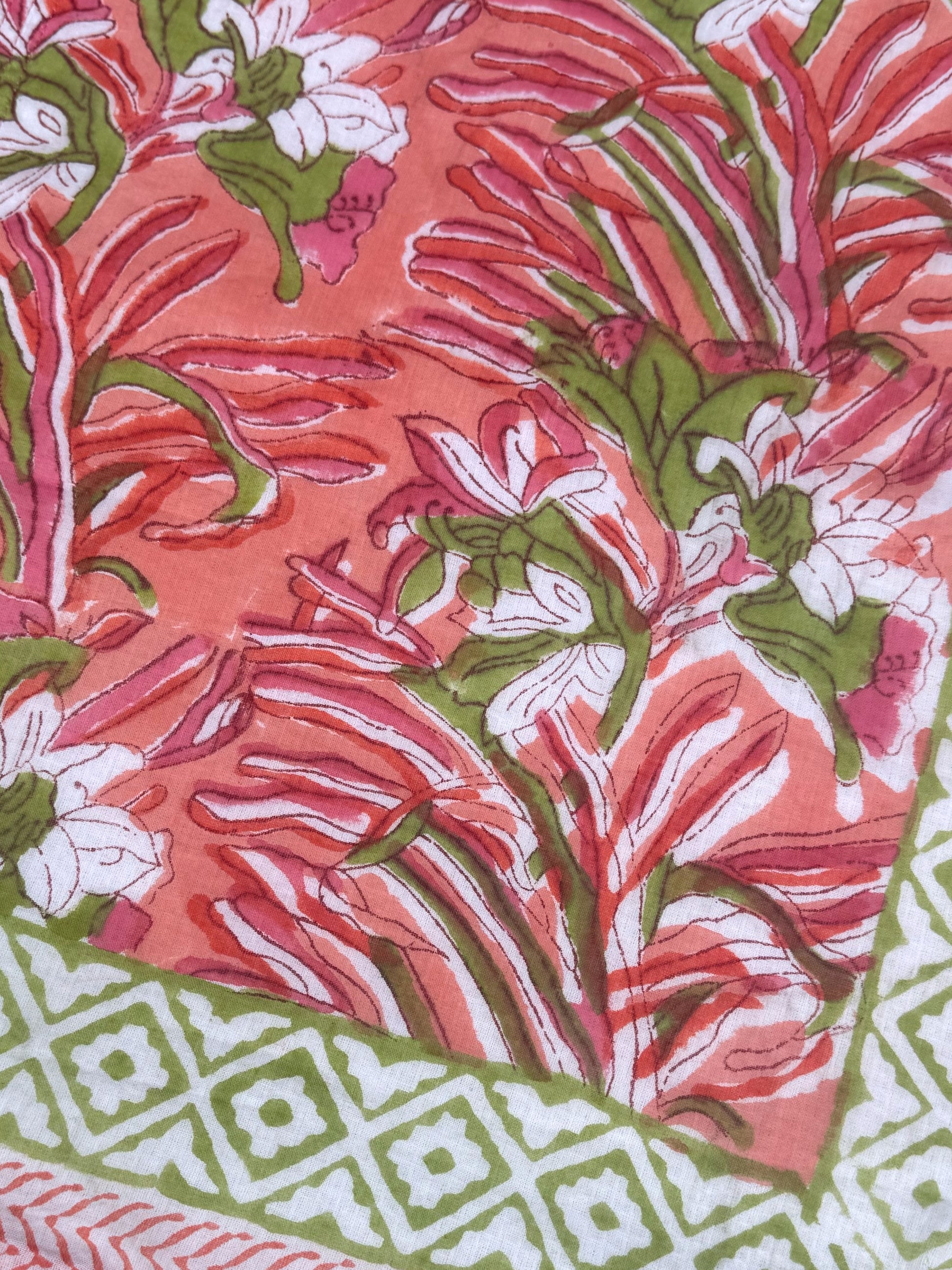 Close-up of a floral fabric with pink, green, and white pattern
