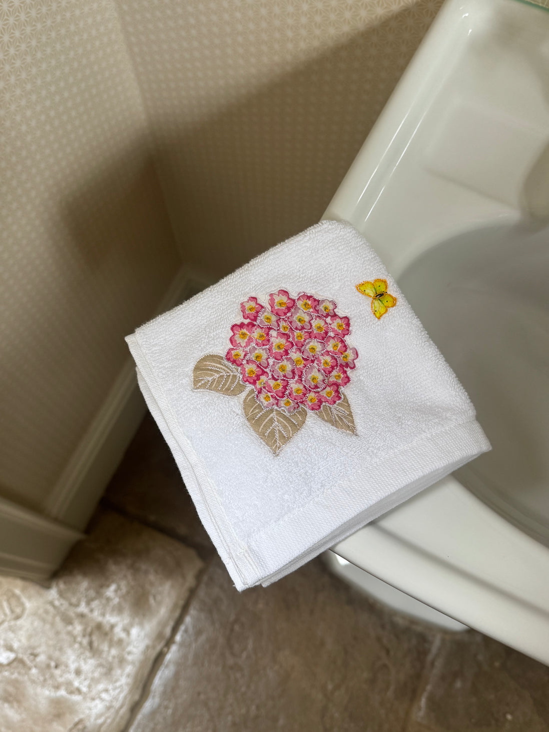 Embroidered face cloth featuring pink hydrangea & butterfly design, 100% cotton