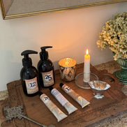 Decorative setup with bottles, candles, and a key on a wooden surface.