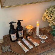 Decorative setup with bottles, candles, and a key on a wooden surface.